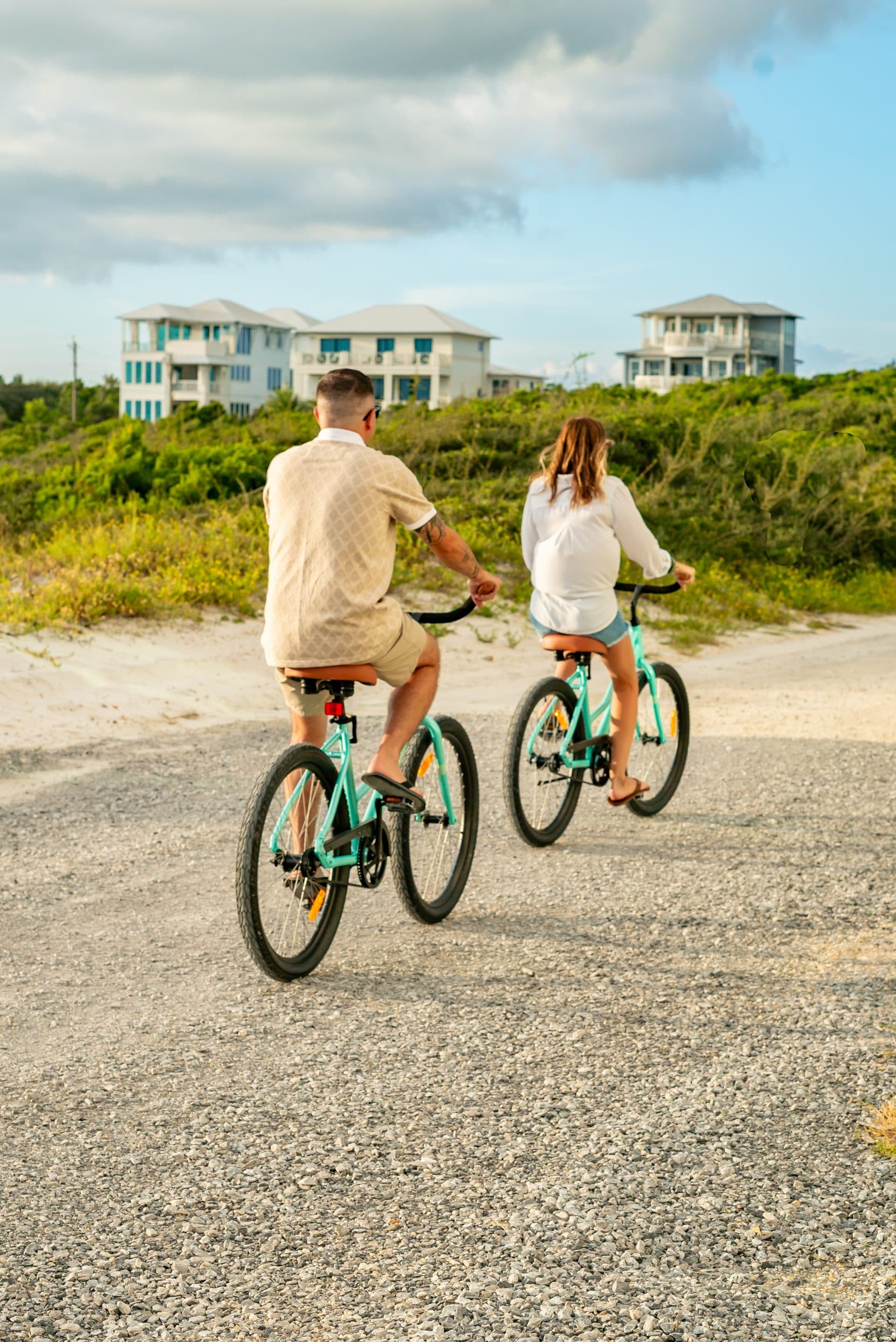 Couple riding Beach Bikes toward the beach